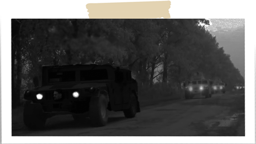 Svart humvee först i kolonn på natten.